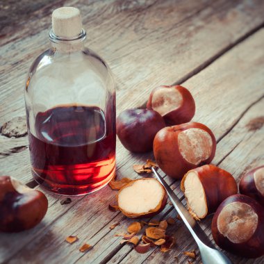 Kestane, bıçak ve şişe üzerinde ahşap masa, herba tentür ile