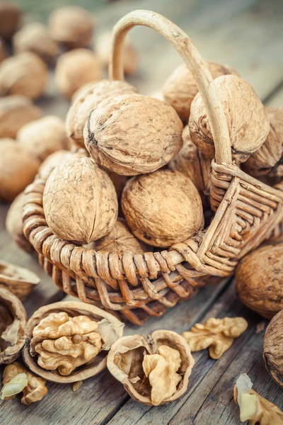 Walnut in basket on old wooden table — Stock Photo, Image