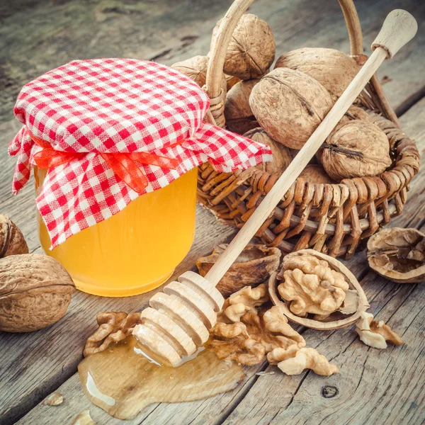 Miel en tarro, nuez en cesta y cazo de madera en cocina vieja — Foto de Stock