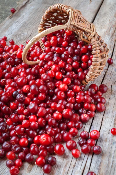 Cranberries vermelhas frescas, bagas e cesta na mesa velha — Fotografia de Stock