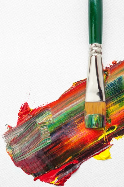 Pinsel und gemischte Ölfarben auf weißer Leinwand — Stockfoto
