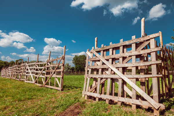 деревянный деревенский забор, голубое небо и сельский пейзаж
