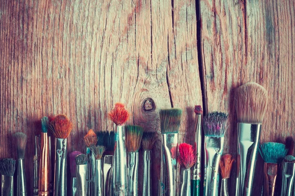 Row of artist paintbrushes closeup on old wooden table, retro st — Stock Photo, Image