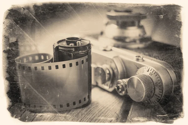 Old photo film roll and retro camera on desk. — Stock Photo, Image