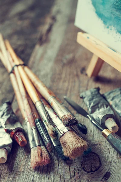 Artistic paintbrushes, tubes of oil paint, palette knife and eas — Stock Photo, Image