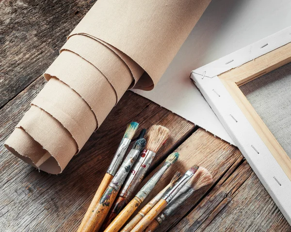 Artist canvas in roll, canvas stretcher and paintbrushes — Stock Photo, Image