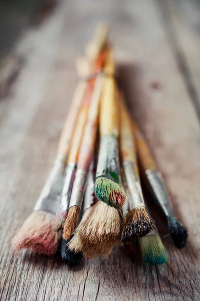 Old artist paintbrushes on rustic wooden table — Stock Photo, Image