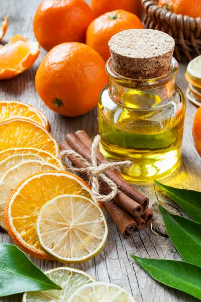 Botella de aceite esencial de cítricos, rodajas secas de naranja y limón, c —  Fotos de Stock