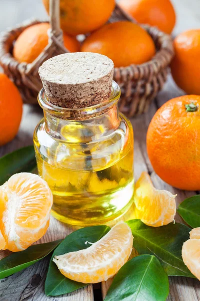 Flaska väsentliga citrus olja och mogen tangeriner i korg på — Stockfoto