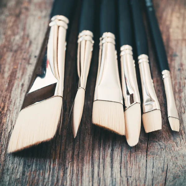 Conjunto de pincéis de artista closeup sobre mesa de madeira rústica . — Fotografia de Stock