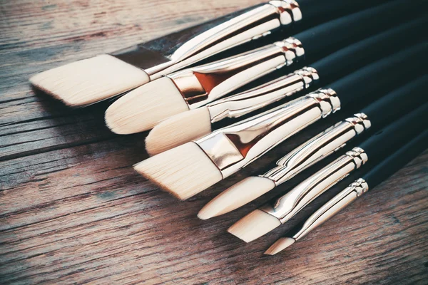 Conjunto de pincéis de artista closeup sobre mesa rústica — Fotografia de Stock