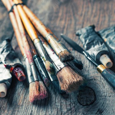 Artistic paintbrushes, tubes of oil paint, palette knife on old clipart