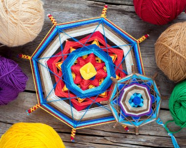 Two knitted tibetan mandala from threads and yarn on wooden rust clipart