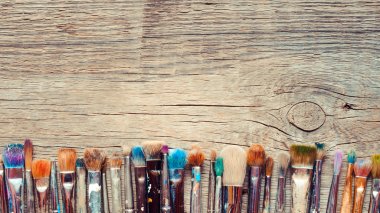 Row of artist paintbrushes closeup on old wooden rustic backgrou clipart