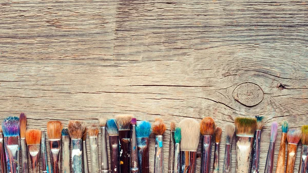 Row of artist paintbrushes closeup on old wooden rustic backgrou — Stock Photo, Image