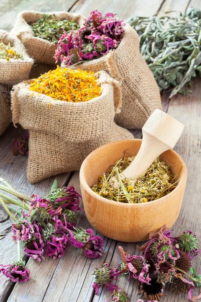 Healing herbs in wooden mortar and in hessian bags, herbal medic — Stock Photo, Image