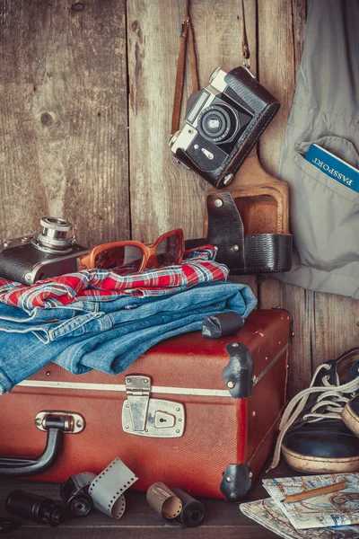 Vecchia valigia da viaggio, scarpe da ginnastica, abbigliamento, occhiali da sole, mappe, film — Foto Stock