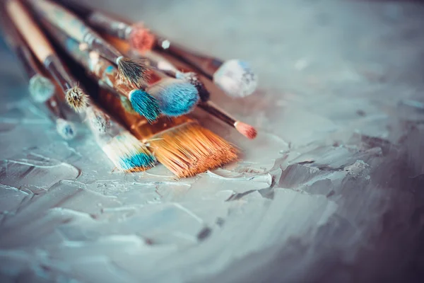 Pędzle na płótnie artysta pokryte farbami olejnymi — Zdjęcie stockowe
