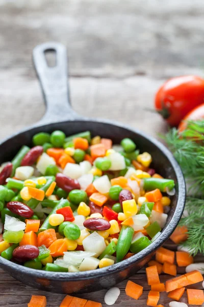 Mixed vegetable meal in old black frying pan closeup and ingredi — Stock Photo, Image