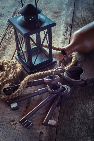 Old lock with keys, vintage lamp, bottle from clay and rope on w — Stock Photo, Image