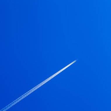 Uçakta açık mavi gökyüzü, beyaz contrail izleme.