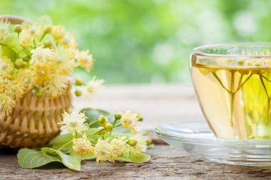 Cup of linden tea and wicker basket with lime flowers, herbal me