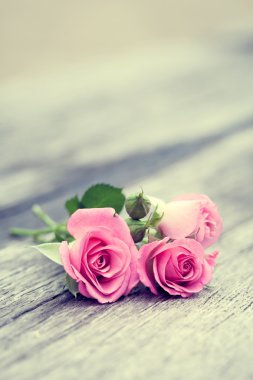 Eski ahşap zemin üzerine gül demet Vintage stilize fotoğraf.