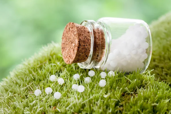 Fles van homeopathie bolletjes op groene mos — Stockfoto