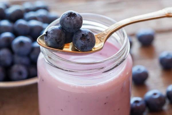 Yogur de arándanos frescos en frasco de vidrio y cuchara —  Fotos de Stock