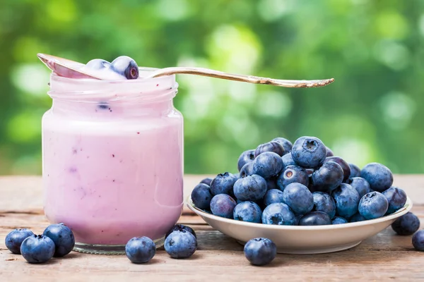 Yogur de arándanos frescos en frasco de vidrio y platillo con arándanos —  Fotos de Stock