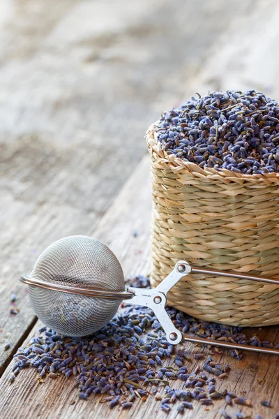 Lavender herbal tea in basket and tea infuser. Selective focus. — Stock Photo, Image