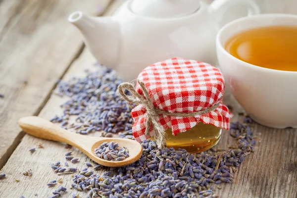 Frasco de mel, flores secas de lavanda, xícara de chá e bule de chá — Fotografia de Stock