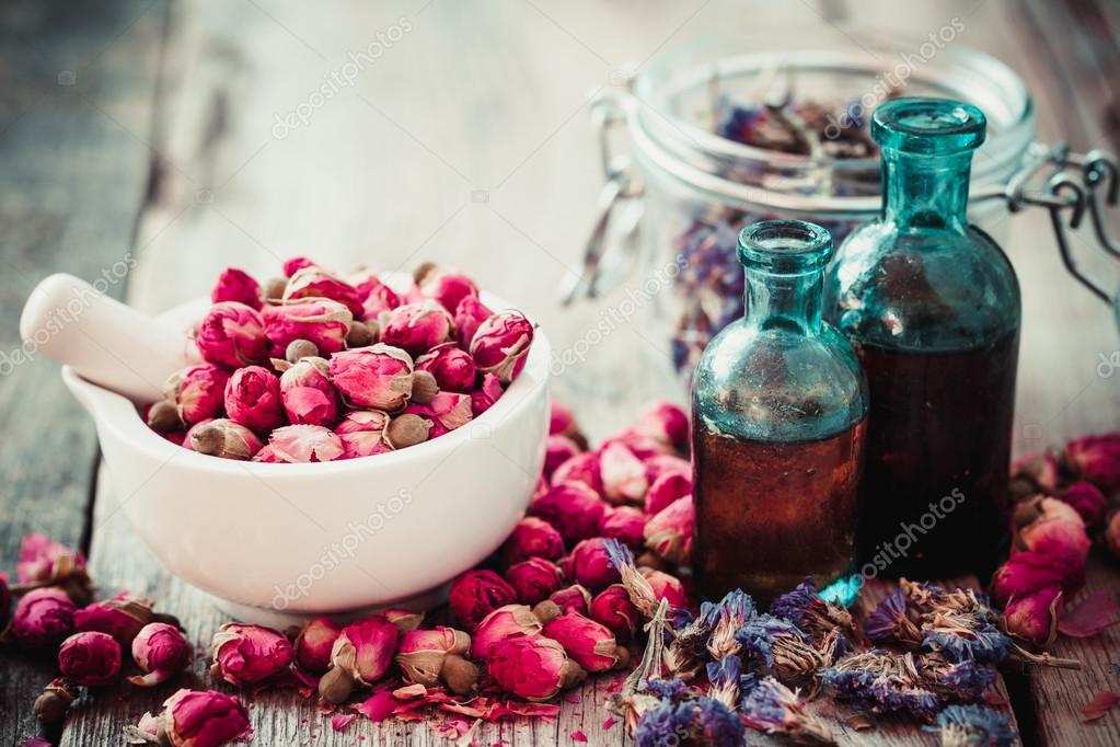 Mortar with rose buds, tincture and dried me not — Stock Photo
