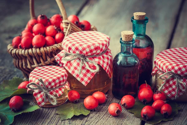 Krukor med honung, tinktur flaskor och murbruk av hagtornsbär — Stockfoto