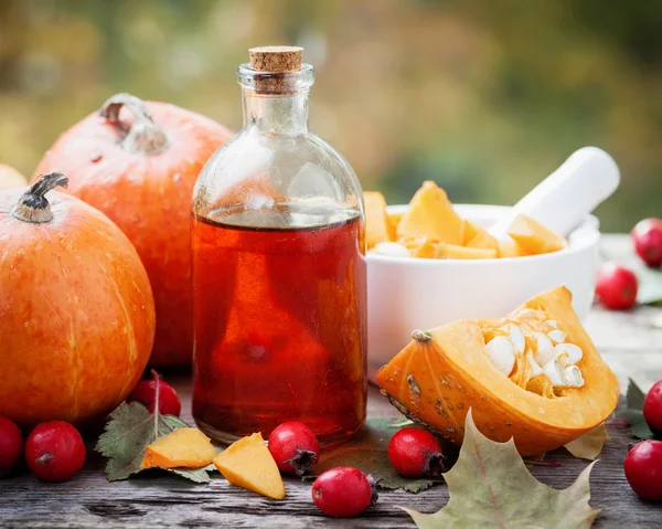 Frasco de aceite de semillas de calabaza, calabazas, bayas de espino y mortero — Foto de Stock