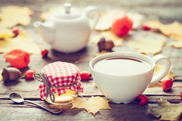 Çay bardağı, kavanoz bal ve arka plan üzerinde çaydanlık. — Stok fotoğraf
