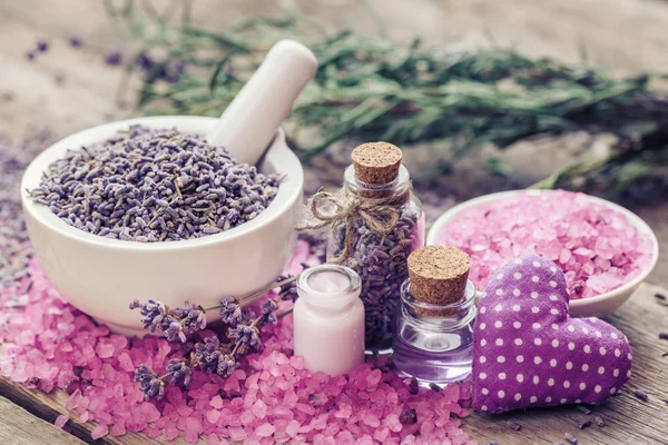 Trockener Lavendel im Mörser, Meersalz, Sahne, ätherischem Öl und textilem Herzen — Stockfoto