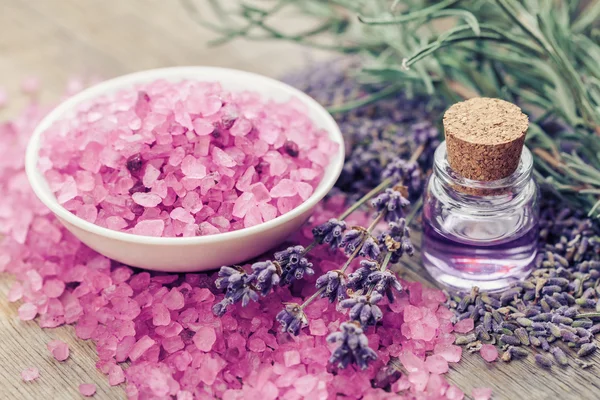 Aromatisches Meersalz, eine Flasche ätherisches Öl und Lavendelblüten. — Stockfoto