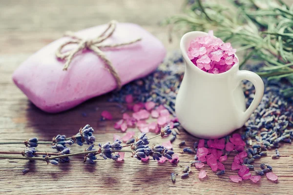 Jarro de sal marinho, barra de sabão caseiro e flores de lavanda seca . — Fotografia de Stock