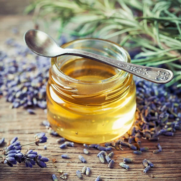 Barattolo di miele, cucchiaio e fiori di lavanda secca per il tè . — Foto Stock