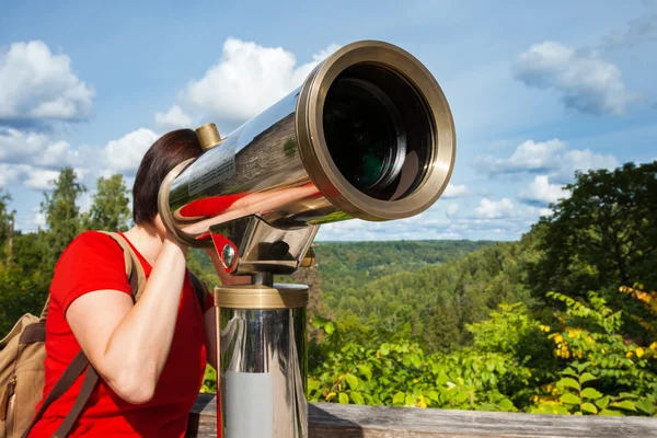 Woman looking through tourist telescope, exploring landscape — Stock Photo, Image