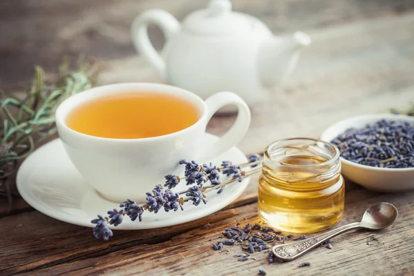 Taza de té saludable, tarro de miel, flores secas de lavanda y tetera —  Fotos de Stock