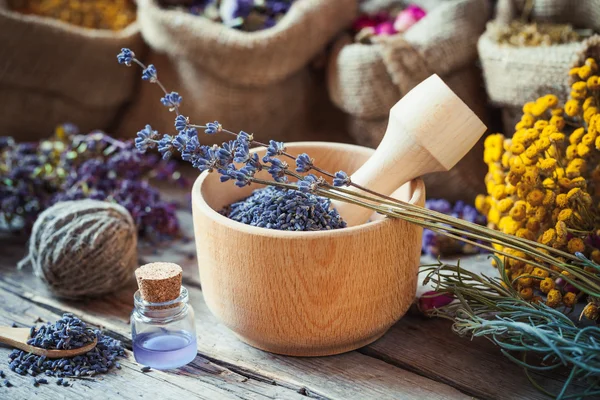 Ervas curativas em sacos hessianos, argamassa de madeira com lavanda — Fotografia de Stock