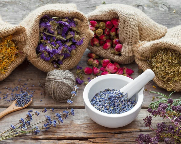 Hierbas curativas en bolsas hessianas y mortero con lavanda seca — Foto de Stock