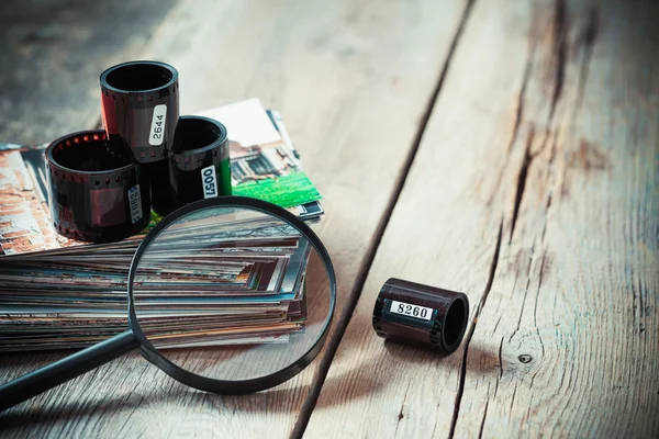 Fotografický film rohlíky, zásobník fotografií a Lupa na stole — Stock fotografie