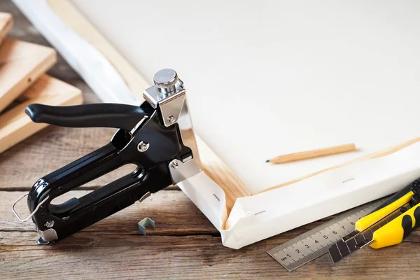 Artist canvas, canvas stretcher and staple gun on table — Stock Photo, Image