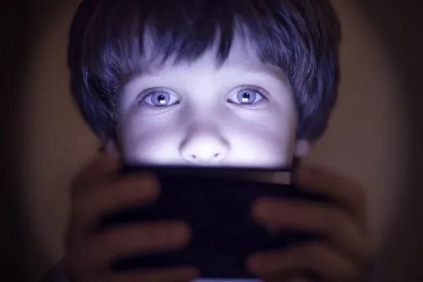 Niño pequeño jugando en un smartphone — Foto de Stock