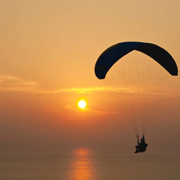 Parachutiste au-dessus de la mer au coucher du soleil — Photo