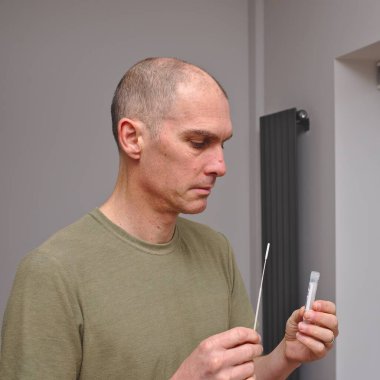 Covid19 kendi kendini test kiti kullanan bir adam.