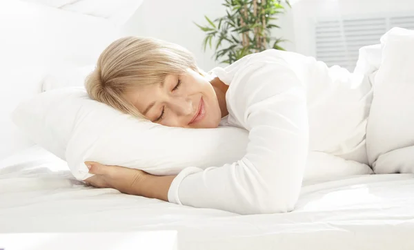 Mulher bonita dormindo na cama branca — Fotografia de Stock
